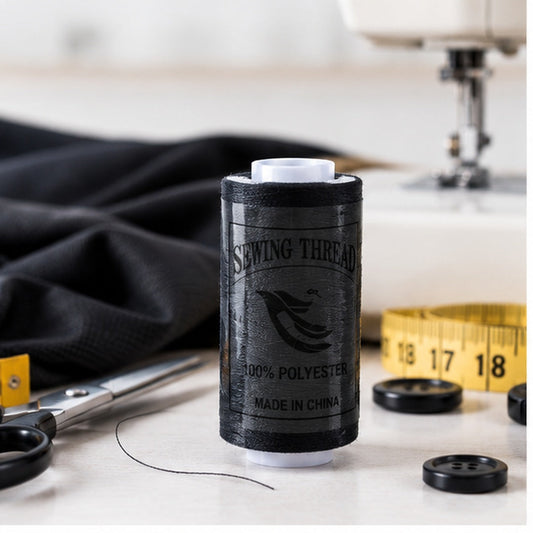 Carrete de hilo negro en mesa de costura