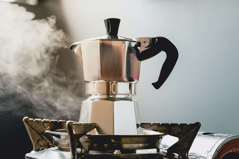Cafetera metálica tipo moka CM-09 sobre una estufa mientras prepara café