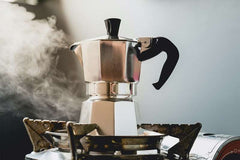 Cafetera metálica tipo moka CM-09 sobre una estufa mientras prepara café