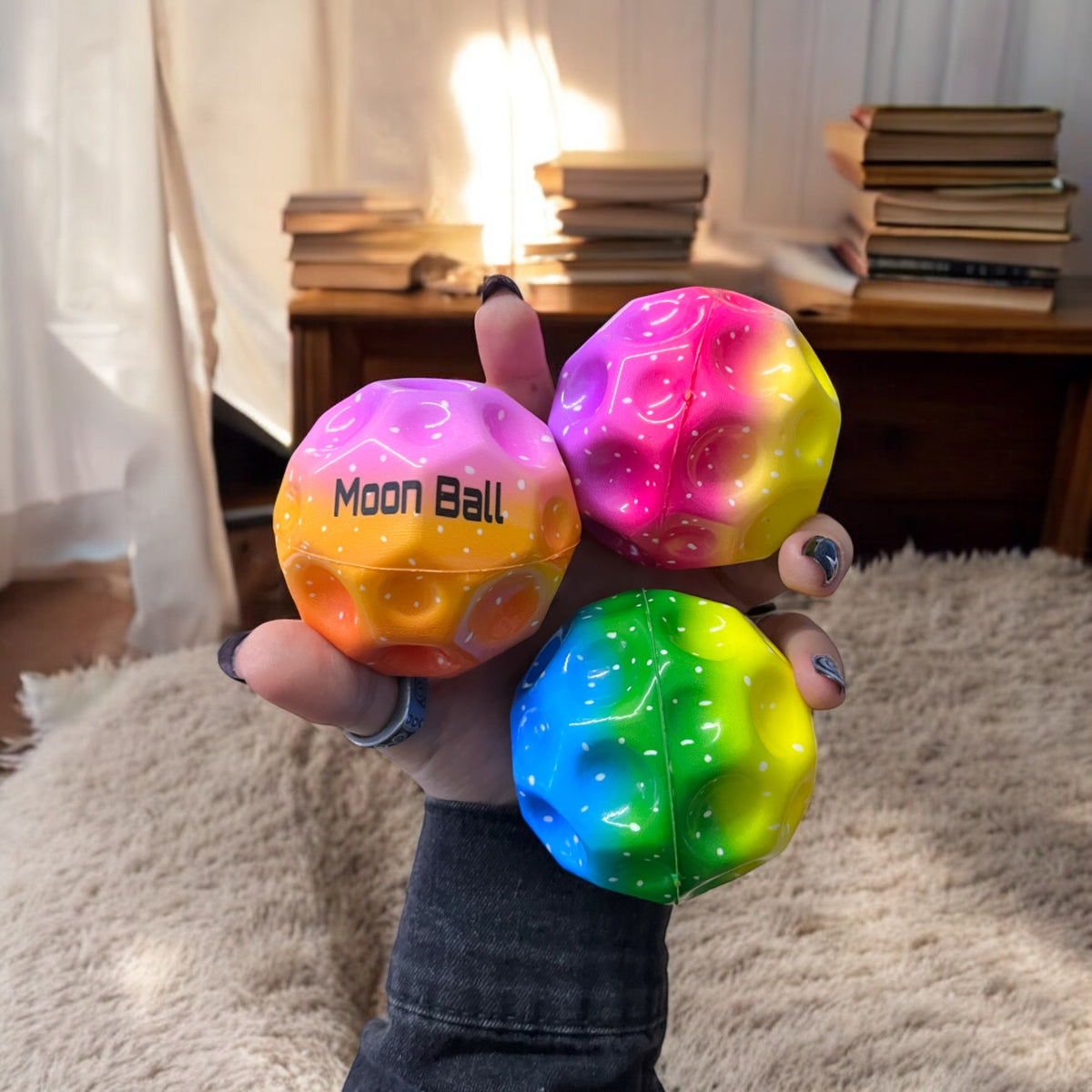 Tres bolas de goma Moon Ball en distintos colores sostenidas juntas
