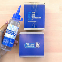 Botella de silicona líquida DL de 100 ml junto a las cajas de empaque del producto.