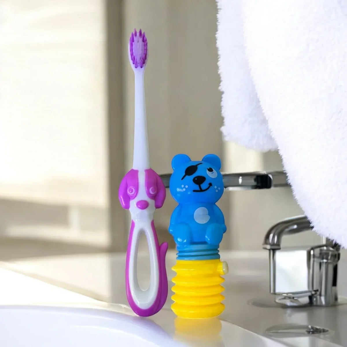 Cepillo dental infantil blanco y fucsia con figura de perro y dispensador de pasta de oso en el baño
