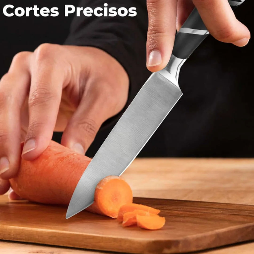 Cuchillo de cocina del set de nueve piezas cortando una zanahoria en tabla