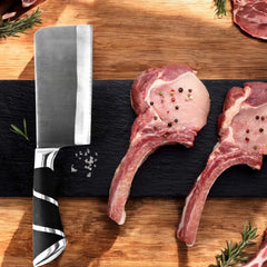 Cuchillo de hoja ancha del set de cocina junto a cortes de carne