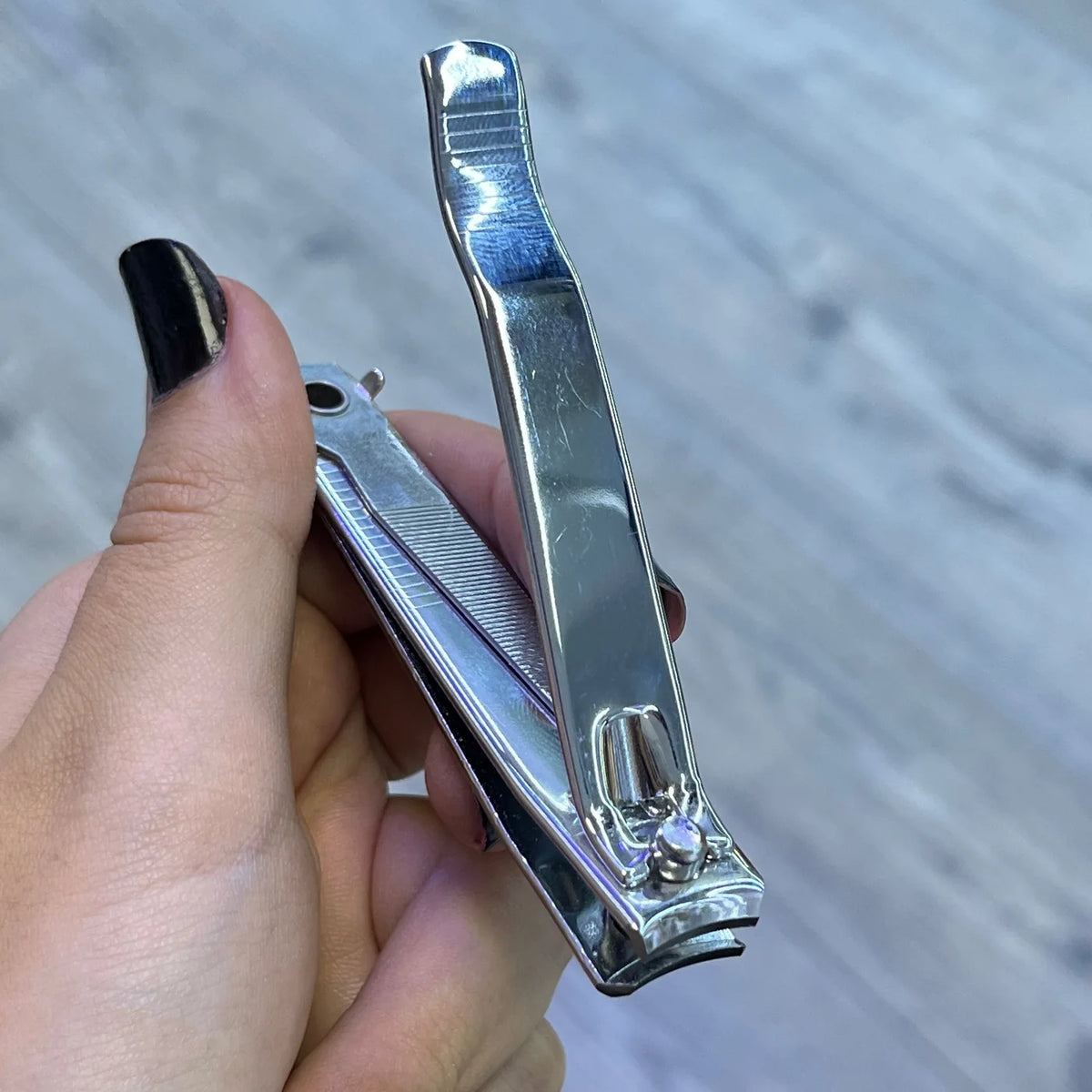 Detalle del cortauñas Trim Curbo grande sostenido en una mano