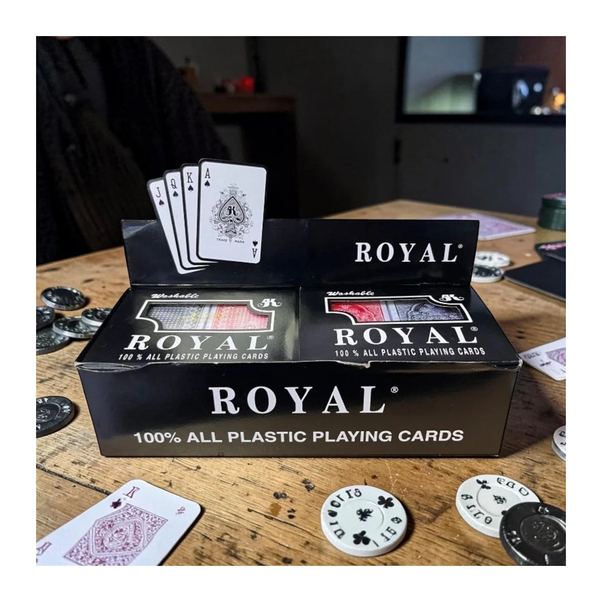 Baraja de cartas Royal 100 % plásticas en exhibidor negro, con cartas de picas visibles.
