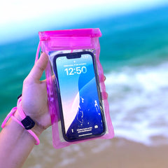 Bolsa impermeable rosa para celular con teléfono dentro, sostenida en la mano
