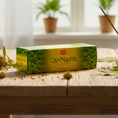 Incienso HEM Cannabis en caja hexagonal verde, vista lateral sobre madera.