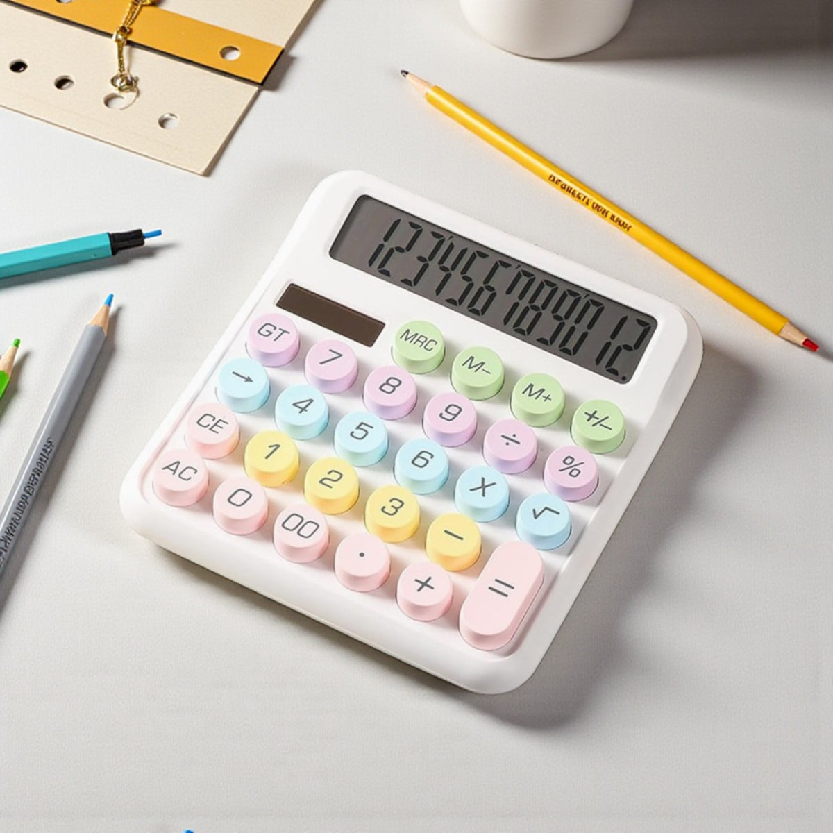 Calculadora blanca de teclas redondas pastel junto a lápices; pantalla con dígitos.