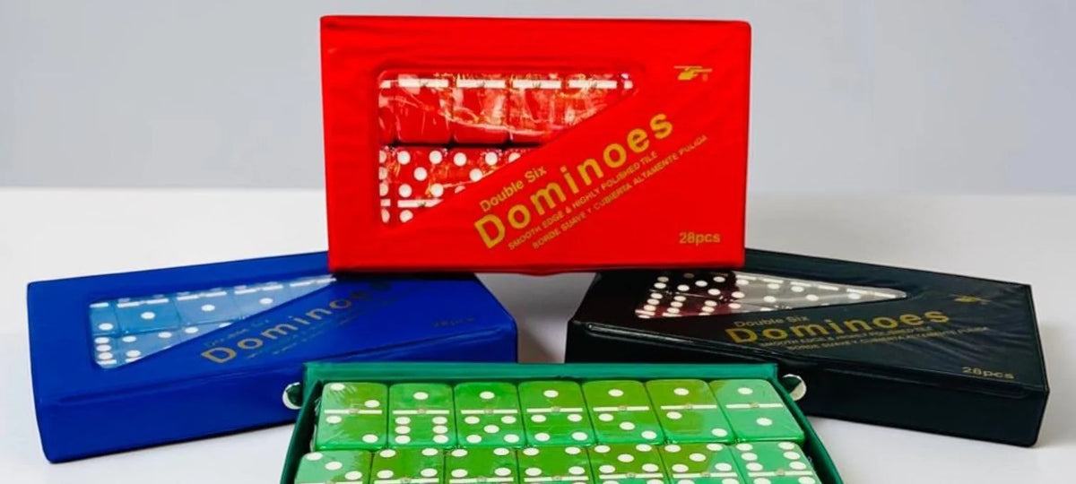 Estuches de dominó doble seis en colores rojo, azul y negro junto al estuche verde abierto; foto de Aleko del SKU T146-TFB-66LPV/C.