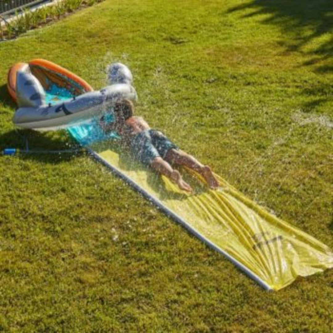 Niño deslizándose por el tobogán inflable Intex Mega Shark con rociadores