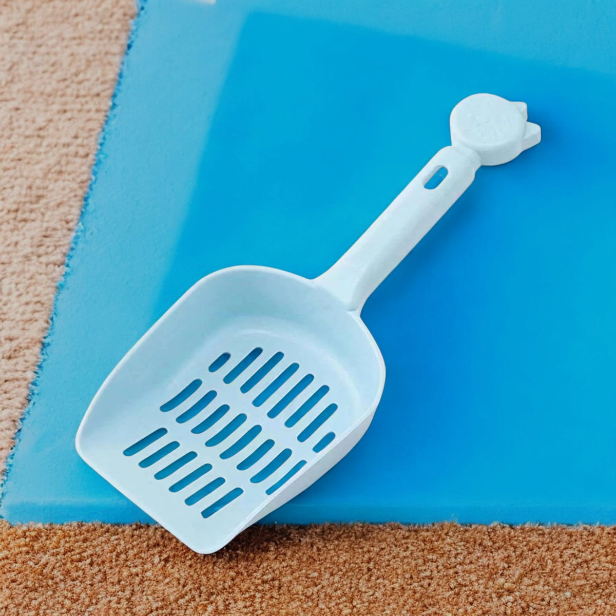 Pala perforada azul para recoger desechos de mascota