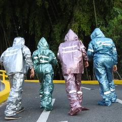 Cuatro personas muestran trajes impermeables finos en varios colores, vista posterior.