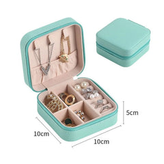 Joyero compacto turquesa AM-1625 abierto con compartimentos para anillos y aretes; la imagen indica 10 × 10 × 5 cm.