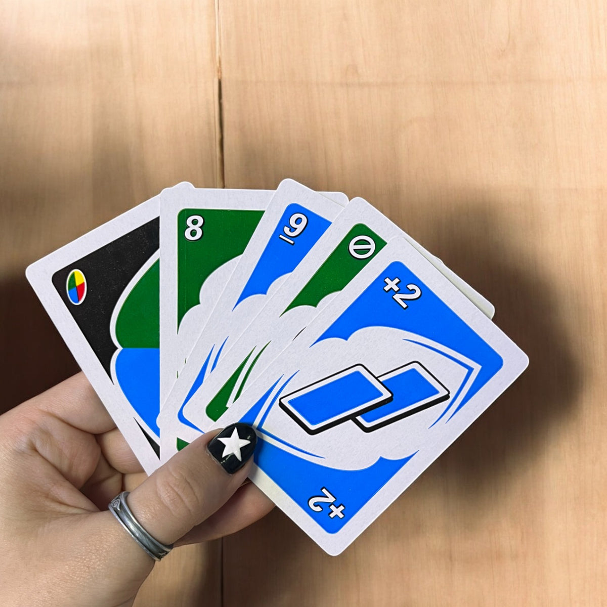 Mano sosteniendo varias cartas de colores del juego UNO