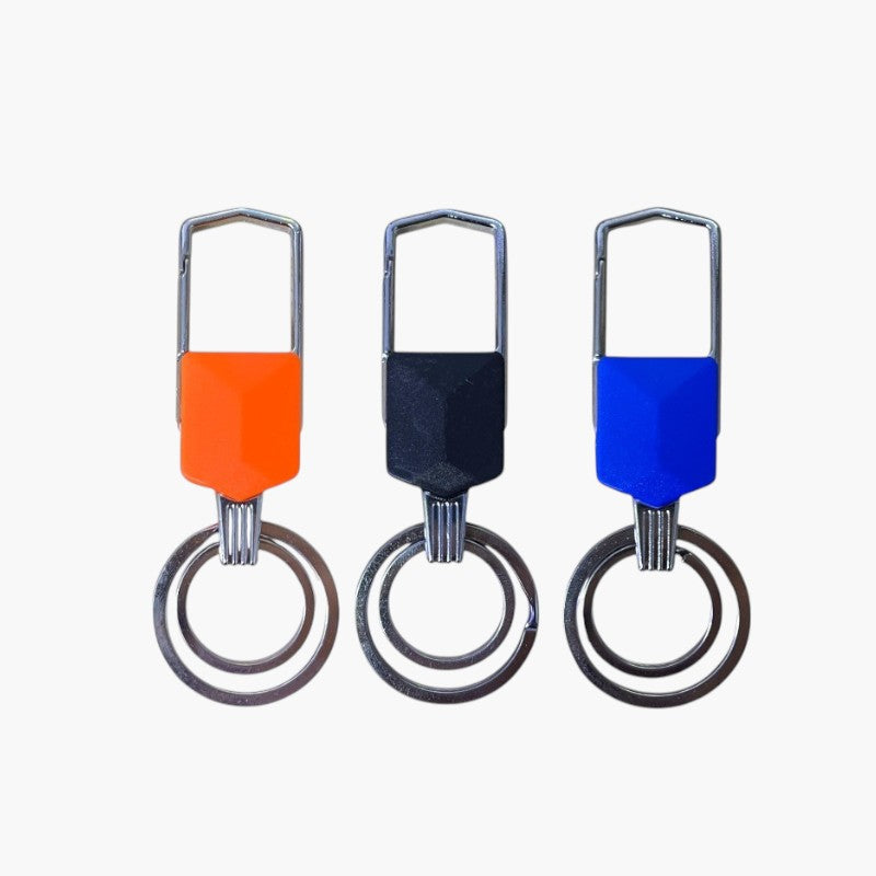 Tres llaveros metálicos con empuñaduras de colores naranja, negro y azul.