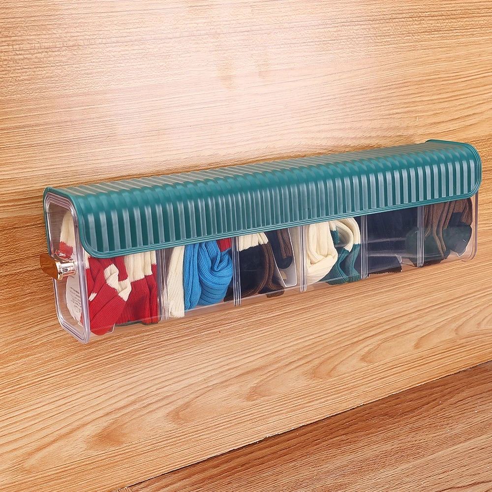 Organizador transparente con tapa verde sobre una mesa de madera