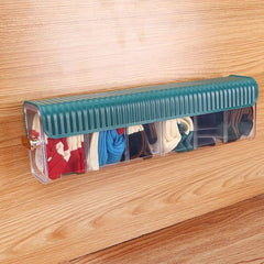 Organizador transparente con tapa verde sobre una mesa de madera