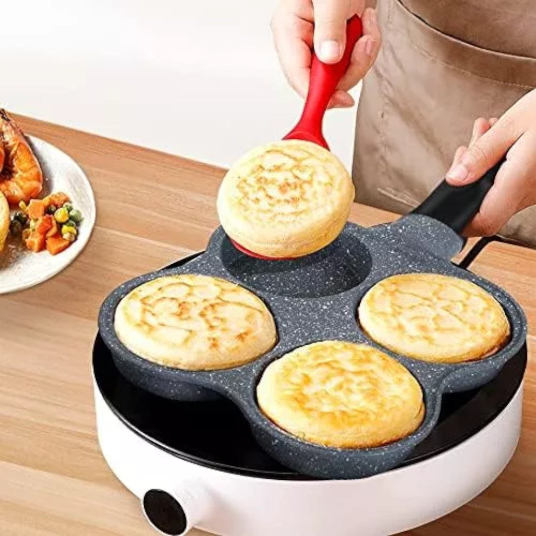 Sartén negra de cuatro cavidades con panqueques preparados.